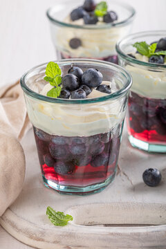 Sweet blue jelly with raw blueberries and whipped cream.