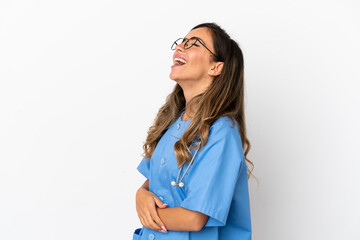 Young surgeon doctor woman over isolated white wall laughing in lateral position
