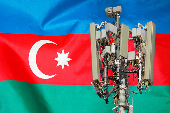 Telecommunications tower with a 5G cellular network antenna agains flag of Azerbaijan. Telecommunication tower of 5G cellular communication. 5G technology usage telecommunications towers in Azerbaijan - Powered by Adobe