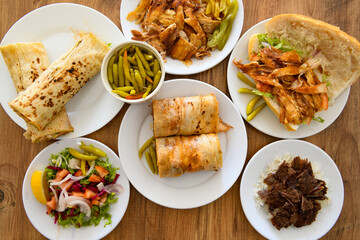 Table scene of assorted take out or delivery foods. Pizza, hamburgers, Doner, fried chicken and sides. Top down view on a table.