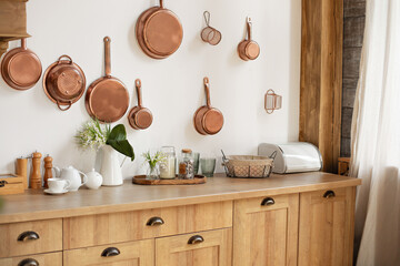 Different kind of cookware and ceramic plates on tabletop wooden kitchen. Set of copper saucepans,...
