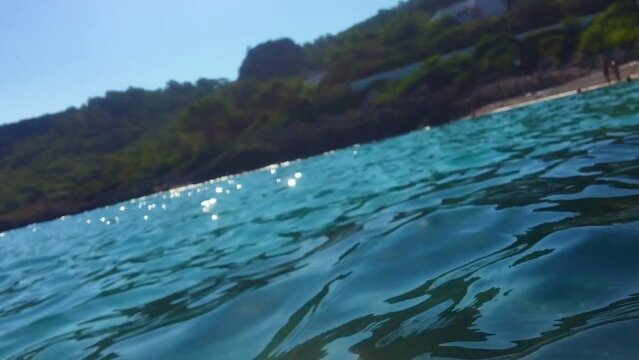 slow-motion blurring of seawater with splash and light glare of the sun, ends under water. blurred image footage