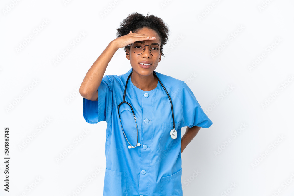 Canvas Prints Young surgeon African American doctor woman isolated on white background looking far away with hand to look something