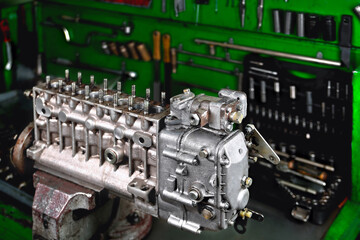 Car fuel pump repair, auto fuel pump dismantling for repair, old car fuel pump on a workbench,...