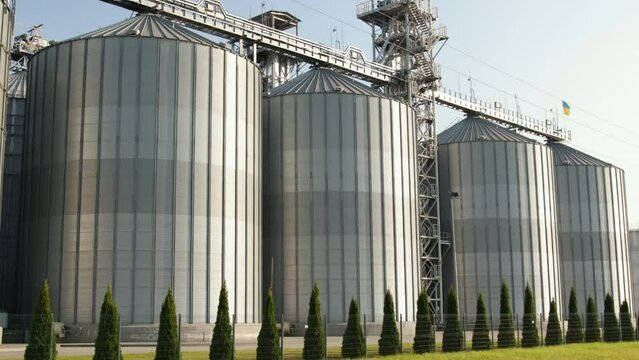 Agricultural silos. Storage and drying of grains, wheat, corn, soy, sunflower. Industrial building exterior. Big metallic silver containers close-up. Background of agricultural tanks with copy space.
