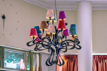 french chandelier with wrought iron details and velor shades of different colors in the interior