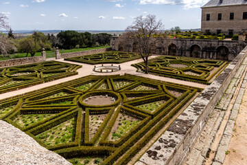 monastery of San Lorenzo de El Escorial with tourists strolling through its gardens and patios in Madrid