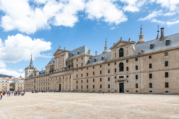 Obraz premium monastery of San Lorenzo de El Escorial with tourists strolling through its gardens and patios in Madrid