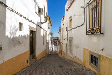 Fototapeta na wymiar Street in the old town of the fortified city of Elvas (World Heritage Site by UNESCO) with its traditional white facades. Alentejo region, Portugal.