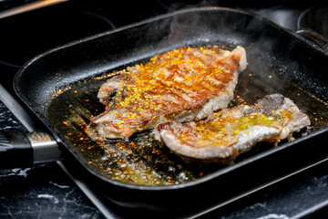 Fried meat in a pan with spices, cut into pieces.