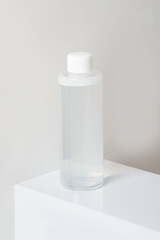 Bottle of micellar water on a pedestal on a white background