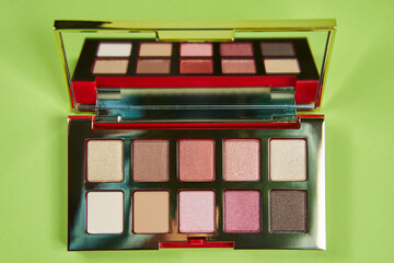 warm eyeshadow palette on a green background