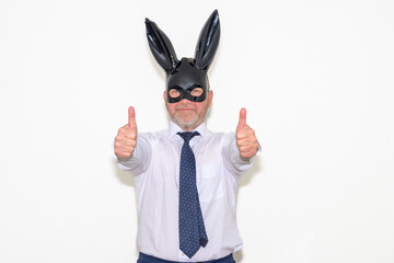 Businessman wearing a bunny mask giving a thumbs up