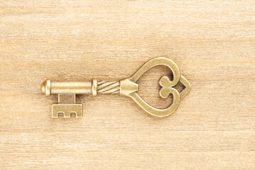 Bronze vintage antique key on brown wooden background. Old keys concept