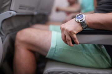 Scared man strongly grab armrest in plane