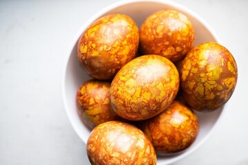 colored colorful chicken eggs in a large white plate as a symbol of the national holiday of believers