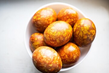 colored colorful chicken eggs in a large white plate as a symbol of the national holiday of believers