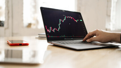 Exchange finance stocks charts monitor trader, candles online, workplace man uses laptop report in...