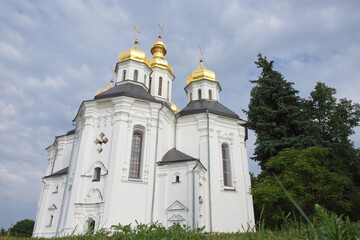 Fototapeta na wymiar Cloudy sky over the ancient Orthodox Church of St. Catherine in the Ukrainian city of Chernihiv. An example of baroque architecture. Church is distinguished by its five gold domes.