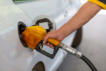 Human hand filling automobile fuel tank. fuel pump