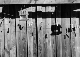 black and white shadow games on a wooden barn wall, bird feeder and shade, morning