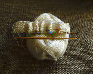 white ball of wool with knitted jacket, handicraft concept