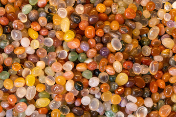 Polished multicolored agate stones in a tray.