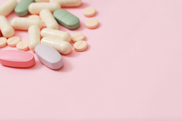 Obraz na płótnie Canvas Pill bottle spilling out. colorful pills capsule on to surface tablets on pink background. drug medical healthcare pharmacy concept. pharmaceuticals antibiotics pills medicine in blister packs.