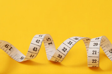 tape measure for obese people on a yellow background soft focus