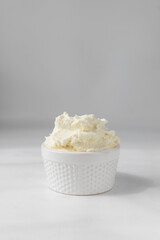 American buttercream in a white ramekin, buttercream with air pockets, textured buttercream in hobnail bowl