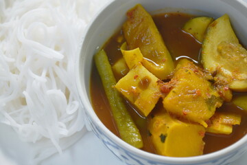 boiled spicy mackerel fish entrails with vegetable curry soup Thai southern style food and rice noodles on plate
