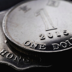 1 one Hong Kong dollar. Fragment of textured coin. Dark dramatic square illustration about economy or finance. Coins and money of Hong Kong. News about banks and currency
