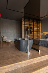 bedroom and freestanding bath behind a glass partition in a chic expensive interior of a luxury...