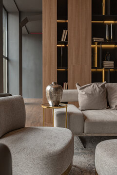 living room, marble wall fireplace and stylish bookcase in chic expensive interior of luxury country house with a modern design with wood and led light, gray furniture with gold elements