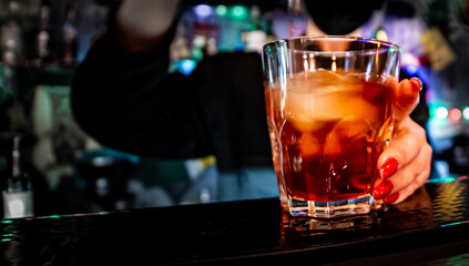 woman hand bartender making negroni cocktail in bar