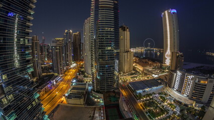 Panoramic view of the Dubai Marina and JBR area and the famous Ferris Wheel aerial night to day timelapse