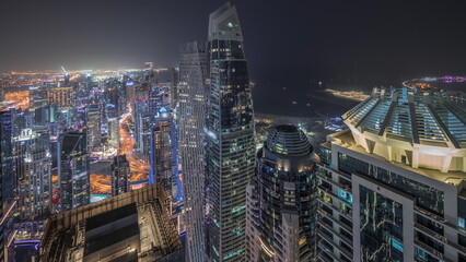 Obraz premium Panorama showing JBR district and Dubai Marina with JLT. Traffic between skyscrapers aerial night timelapse.