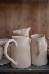 Ready-made ceramic dishes, handmade jugs on a shelf or shop window.