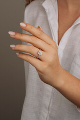 Close up of an elegant engagement diamond ring on female finger. love and wedding. Soft and...