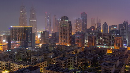 Skyscrapers in Barsha Heights district and low rise buildings in Greens district aerial night to day timelapse.