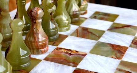 Onyx chess pieces on a chessboard. Black team perspective on the field of play