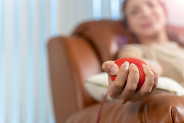 Close-up, Hand of blood donor squeezes the rubber bulb in the form of heart in her hand.