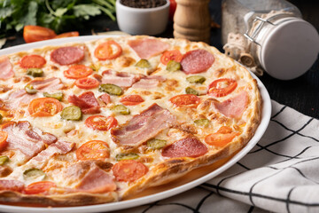 pizza with ham, sausage, tomatoes.
