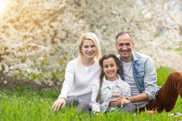 Fototapeta premium Happy family having picnic in nature. Smiling family picnicking in the park. spring nature