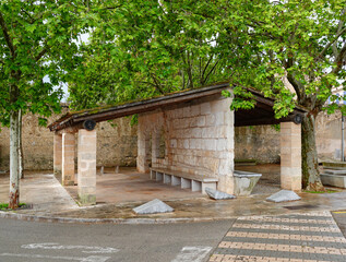Ein gemauertes Wartehäuschen mit Holzdach unter einem Baum in Sant Llorenç des Cardassar, Mallorca
