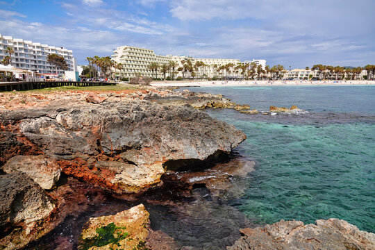 Blick &uuml;ber Felsen und Meer hin zum Sandstrand von Sa Coma, Mallorca