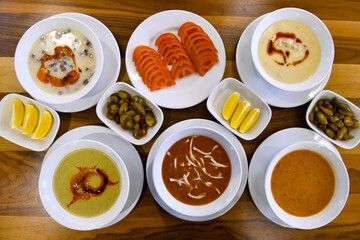 Top view of table scene with assorted take out or delivery foods. Meat and chicken doner kebab sandwich, wrap and on the plate with vegetables and sauce, including fries and pickles.
