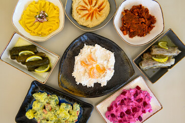 Top view of table scene with assorted take out or delivery foods. Meat and chicken doner kebab sandwich, wrap and on the plate with vegetables and sauce, including fries and pickles.