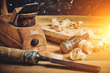 Carpenters tool kit, hammer, chisel and plane on a wooden background with shavings.