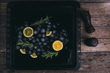 Melting ice cubes, pepper shakers, lemon and rosemary.Abstract background, cooking.
